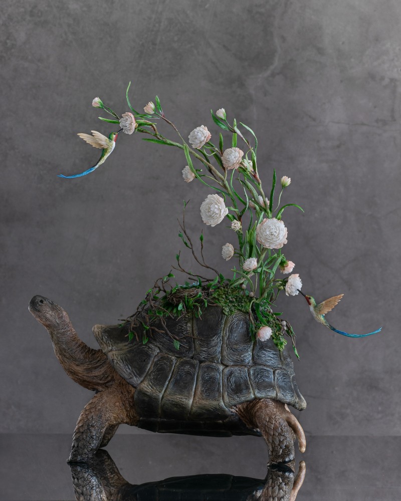 Handmade tortoise statue with flowers and hummingbird 