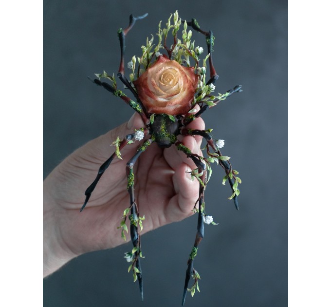 Handmade black spider sculpture with a rose made of air clay